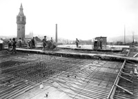 Workers pour concrete over reinforcing iron, 1914