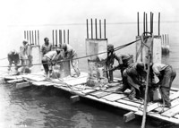 Laborers demolish a pier in 1928