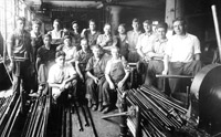 Steamfitters pose with piles of pipe they will cut on the job, circa 1920s